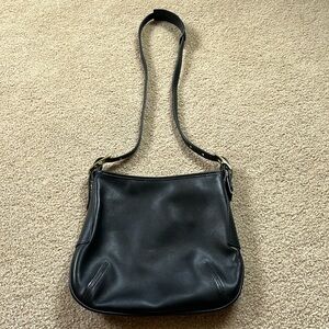 Coach black leather should bag with zipper closure and interior pocket.